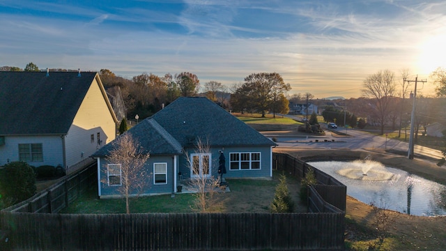 back house at dusk with french doors and a yard