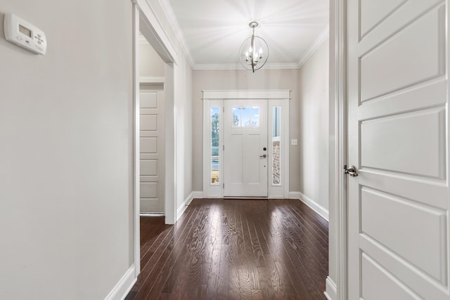 foyer with dark hardwood / wood-style flooring, a chandelier, and ornamental molding