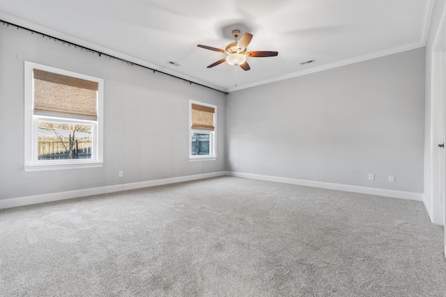 spare room featuring carpet floors, crown molding, ceiling fan, and a healthy amount of sunlight