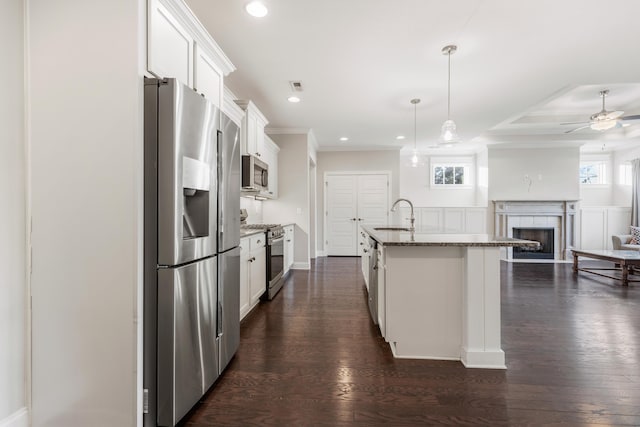 kitchen with dark wood-type flooring, a center island with sink, white cabinets, and stainless steel appliances