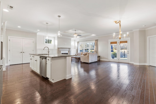 kitchen with white cabinets, dark hardwood / wood-style flooring, an island with sink, and hanging light fixtures