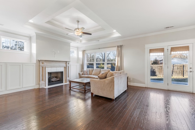 living room with dark hardwood / wood-style floors, a healthy amount of sunlight, and crown molding