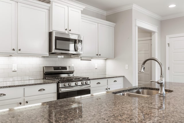 kitchen with white cabinetry, sink, appliances with stainless steel finishes, and dark stone counters