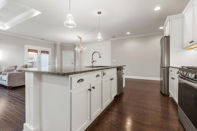 kitchen with appliances with stainless steel finishes, dark hardwood / wood-style flooring, sink, white cabinetry, and an island with sink