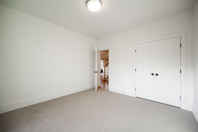 unfurnished bedroom featuring carpet flooring and a closet