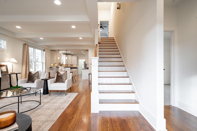 stairway featuring beam ceiling and hardwood / wood-style flooring