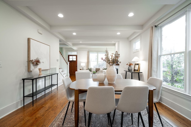 dining space featuring beam ceiling and hardwood / wood-style flooring