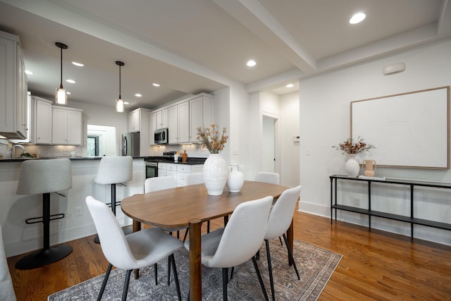 dining room featuring beamed ceiling and dark wood-type flooring