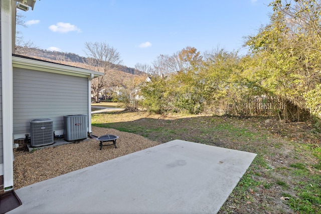 view of yard featuring a patio area, a mountain view, and central AC