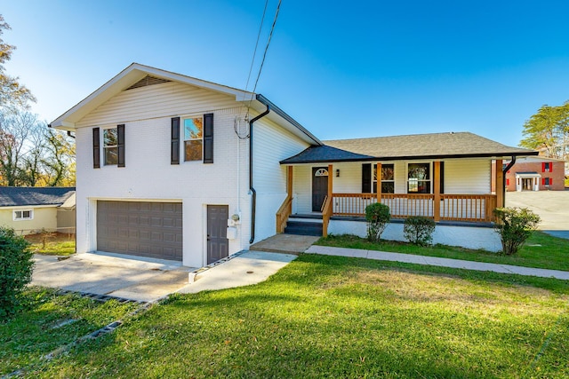 tri-level home featuring a porch, a garage, and a front lawn