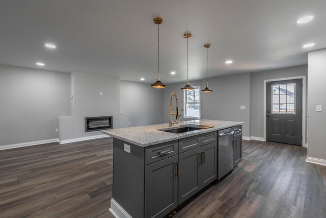 kitchen featuring pendant lighting, a center island with sink, stainless steel dishwasher, and sink