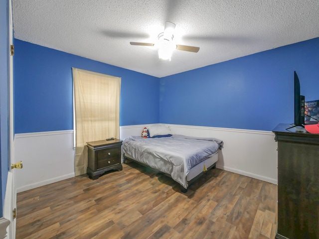 bedroom featuring a textured ceiling, ceiling fan, and dark hardwood / wood-style floors