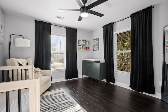 bedroom featuring ceiling fan, wood finished floors, visible vents, and baseboards