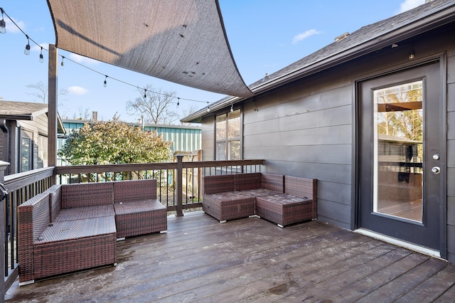 wooden terrace with an outdoor living space