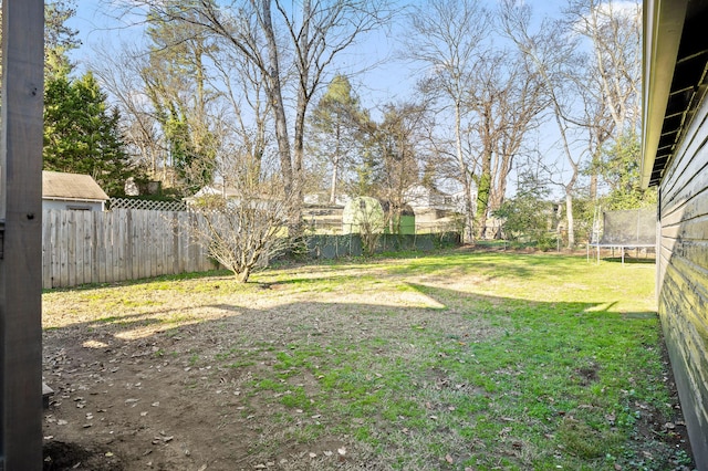 view of yard with a trampoline and a fenced backyard