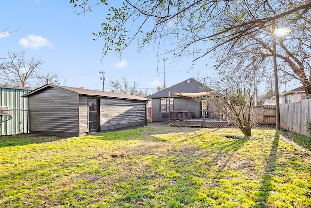 view of yard featuring an outdoor structure, a fenced backyard, and a wooden deck