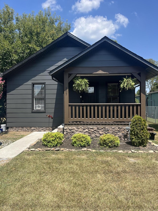 view of front of home with a porch and a front lawn