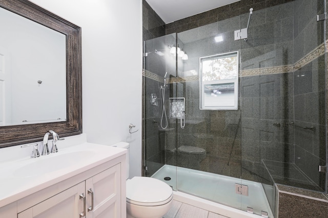 bathroom with an enclosed shower, vanity, toilet, and tile patterned floors