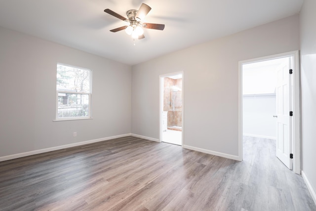 empty room with ceiling fan and light wood-type flooring