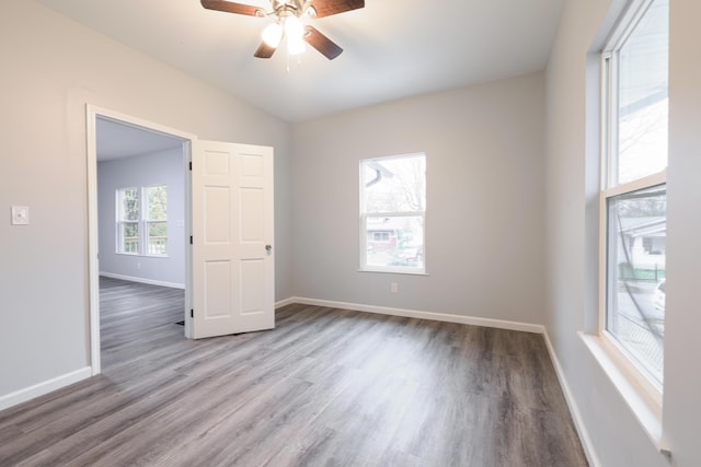 spare room with ceiling fan, vaulted ceiling, and hardwood / wood-style flooring