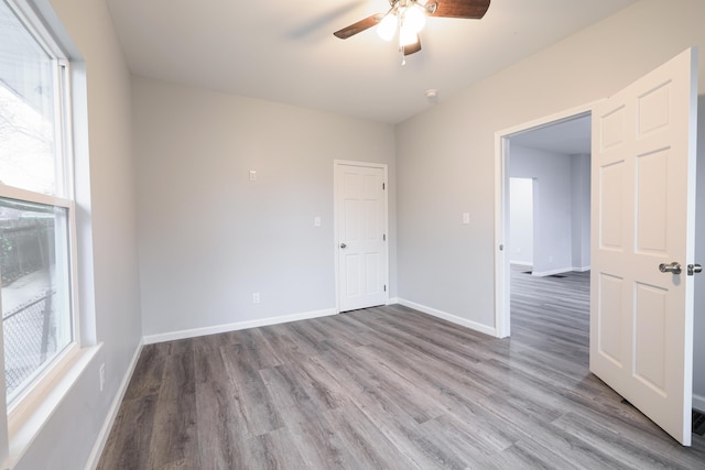 spare room with ceiling fan, a healthy amount of sunlight, and light wood-type flooring