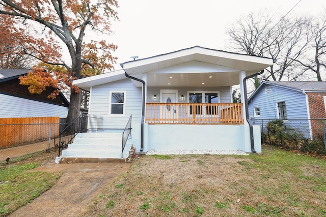 rear view of property featuring a yard and covered porch