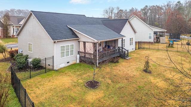 back of house featuring a trampoline and a lawn