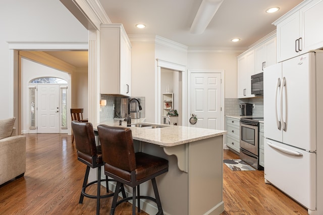 kitchen with white cabinets, stainless steel electric range oven, hardwood / wood-style floors, and white fridge