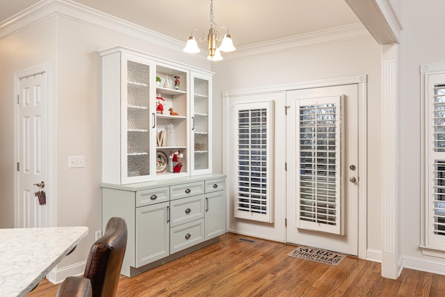 interior space featuring a chandelier, light wood-type flooring, and crown molding