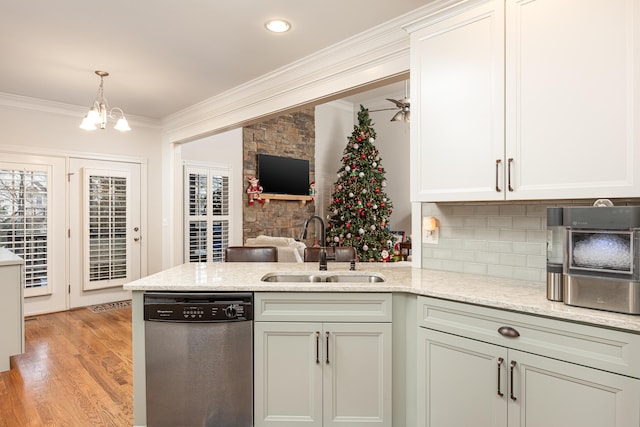 kitchen featuring dishwasher, sink, light hardwood / wood-style floors, ceiling fan with notable chandelier, and ornamental molding