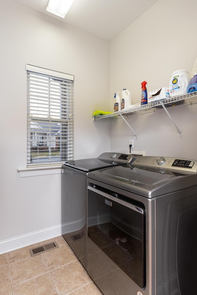 laundry room featuring washing machine and dryer and light tile patterned floors