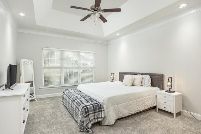 carpeted bedroom with a raised ceiling, ceiling fan, and ornamental molding