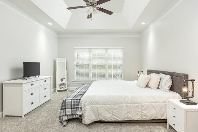 carpeted bedroom featuring a tray ceiling, ceiling fan, and ornamental molding