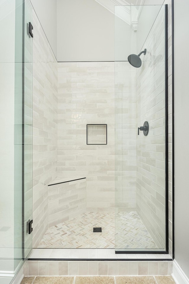 bathroom featuring an enclosed shower and ornamental molding