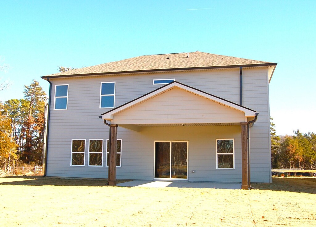 rear view of house featuring a patio area and a lawn