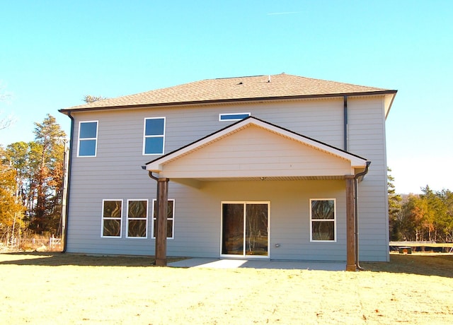 rear view of house featuring a patio area and a lawn