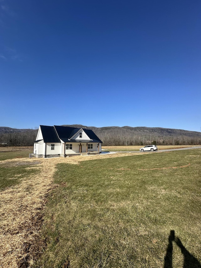 exterior space featuring a mountain view, a rural view, and a front yard