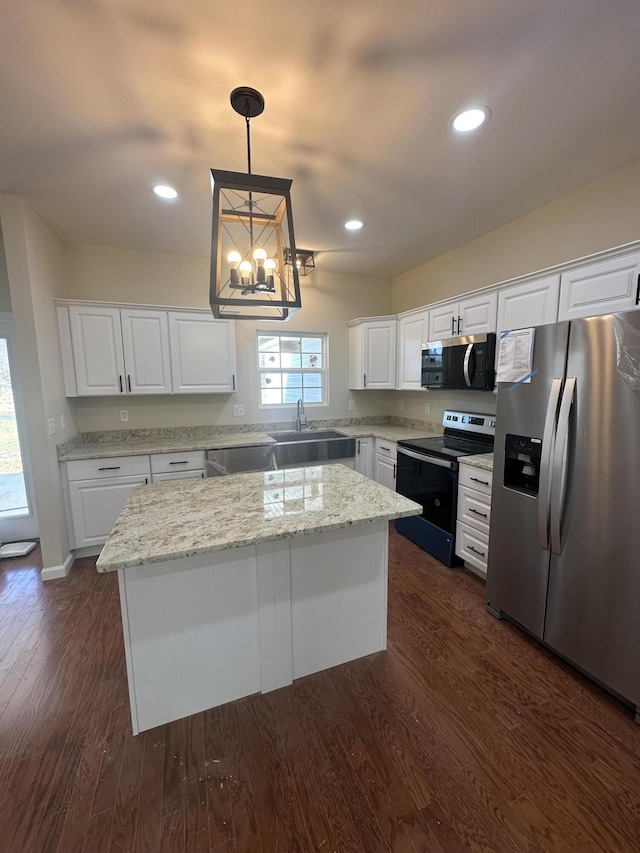 kitchen featuring white cabinets, stainless steel appliances, a center island, and pendant lighting