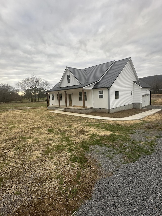 view of front of house featuring crawl space, covered porch, metal roof, and a front lawn