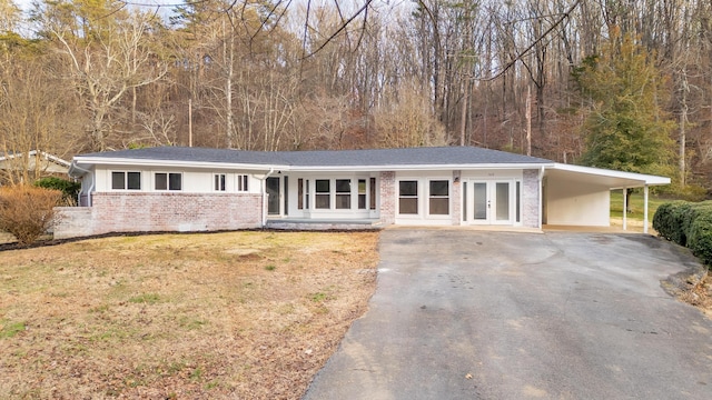 ranch-style home with a carport, a front lawn, and french doors