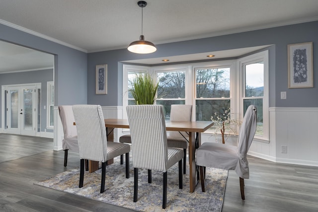 dining space featuring ornamental molding, a textured ceiling, and dark wood-type flooring