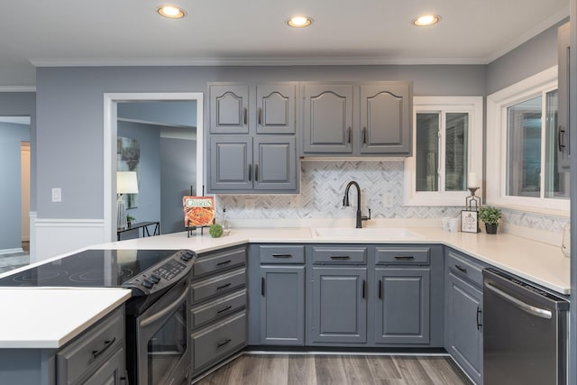 kitchen with gray cabinets, ornamental molding, sink, and appliances with stainless steel finishes