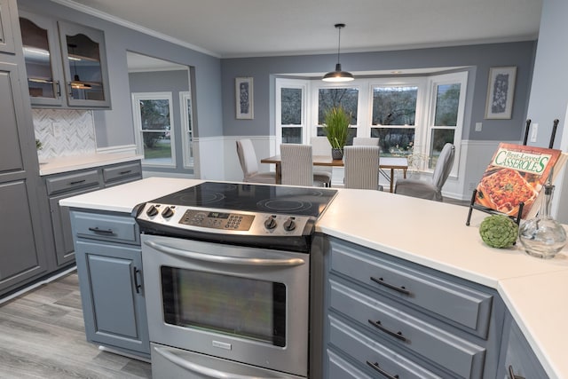 kitchen with pendant lighting, stainless steel electric range, decorative backsplash, gray cabinets, and light wood-type flooring