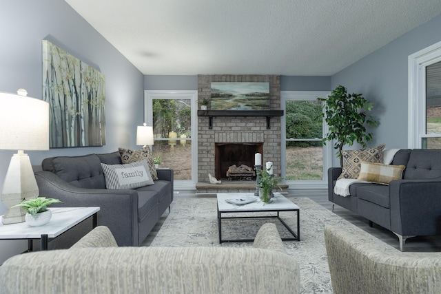 living room featuring a fireplace, a textured ceiling, and hardwood / wood-style flooring