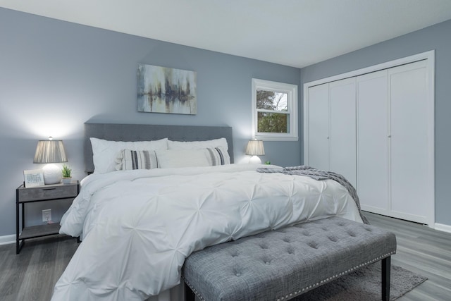 bedroom with dark hardwood / wood-style flooring and a closet