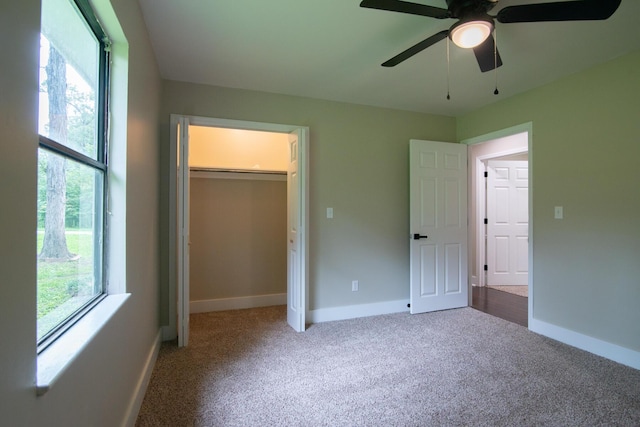 unfurnished bedroom featuring carpet flooring, ceiling fan, a closet, and multiple windows