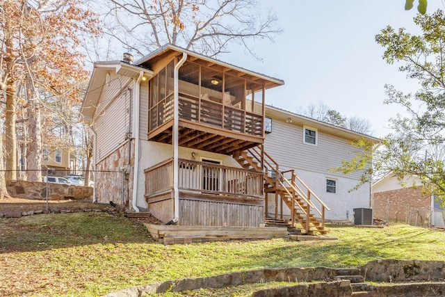 back of property featuring cooling unit, a lawn, and a sunroom