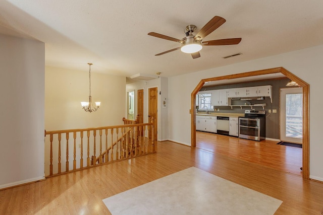 unfurnished living room with sink, light hardwood / wood-style floors, and plenty of natural light