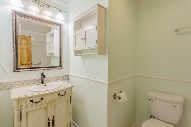 bathroom with vanity, ornamental molding, and toilet