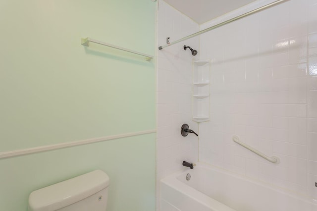 bathroom featuring tiled shower / bath combo and toilet